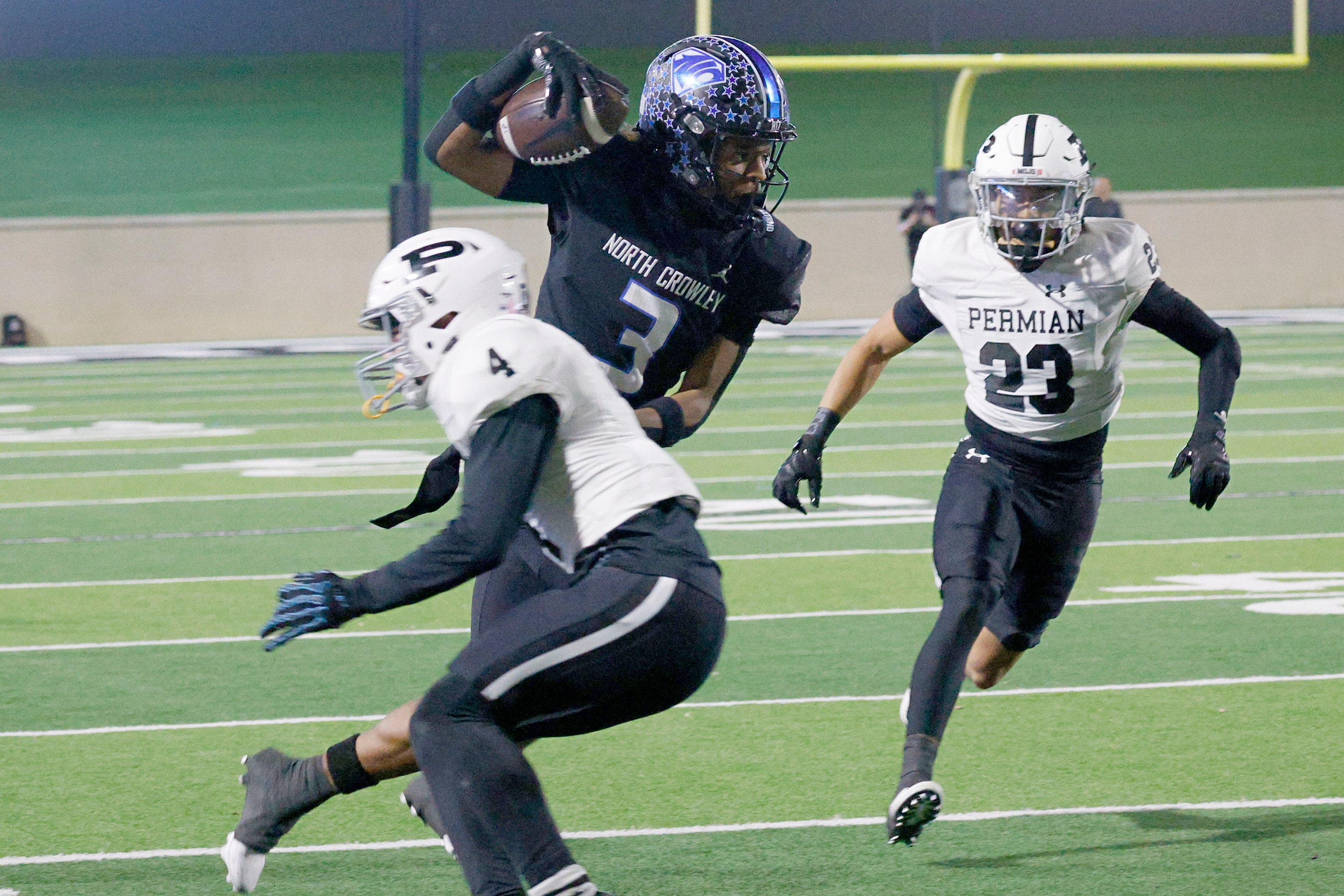 North Crowley's Kevin Moore (3) carries the ball against Permian's Roman Lueras (4) and...