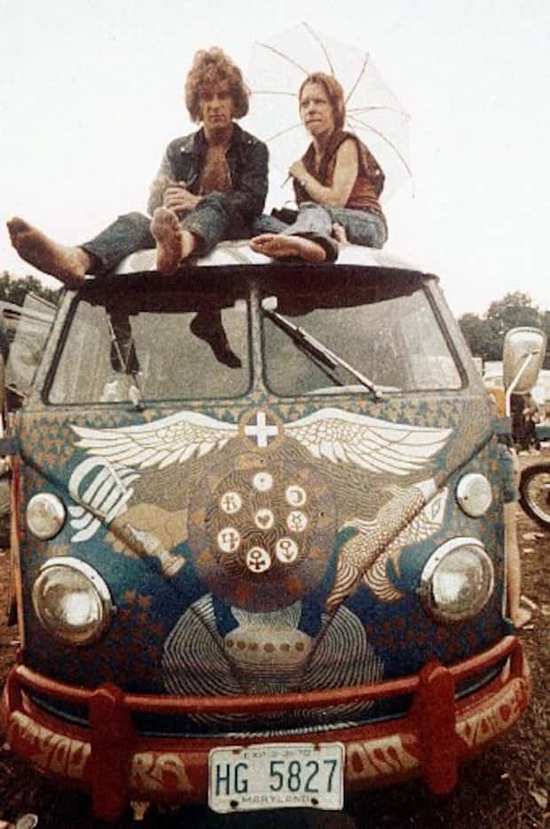 Concert-goers sit on the roof of a Volkswagen bus at the Woodstock Music and Arts Fair at...