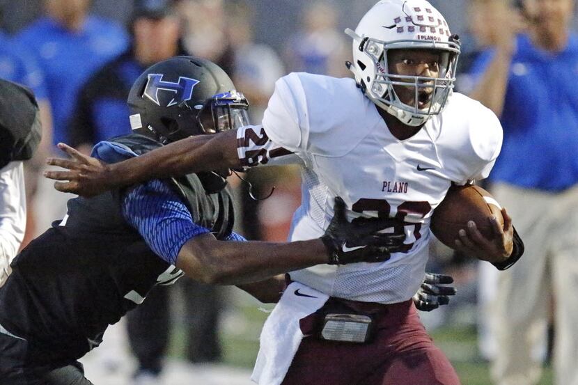 Plano High School quarterback Aaron Ragas is caught from behind during the first quarter as...