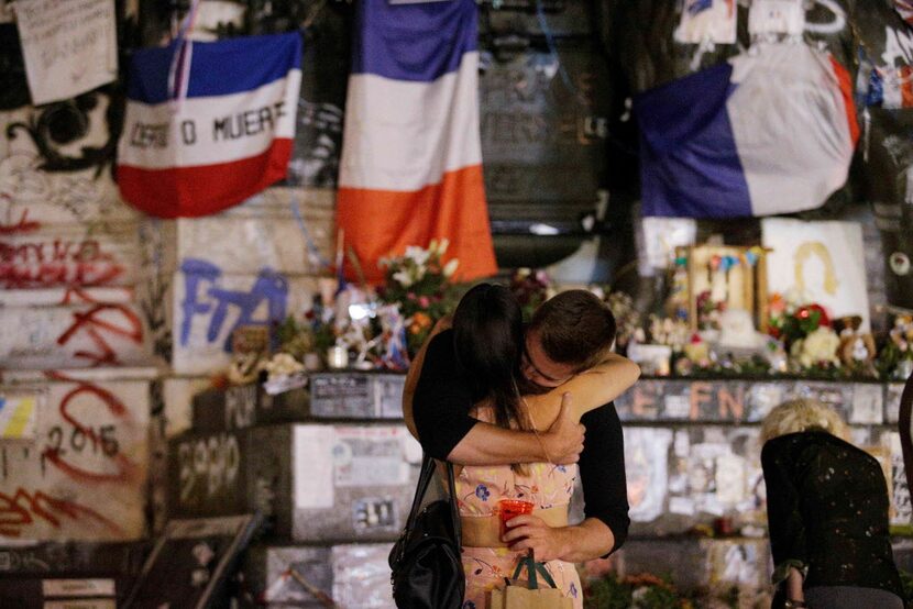 TOPSHOT - People stand in front of the place de la Republique's monument in Paris, on July...