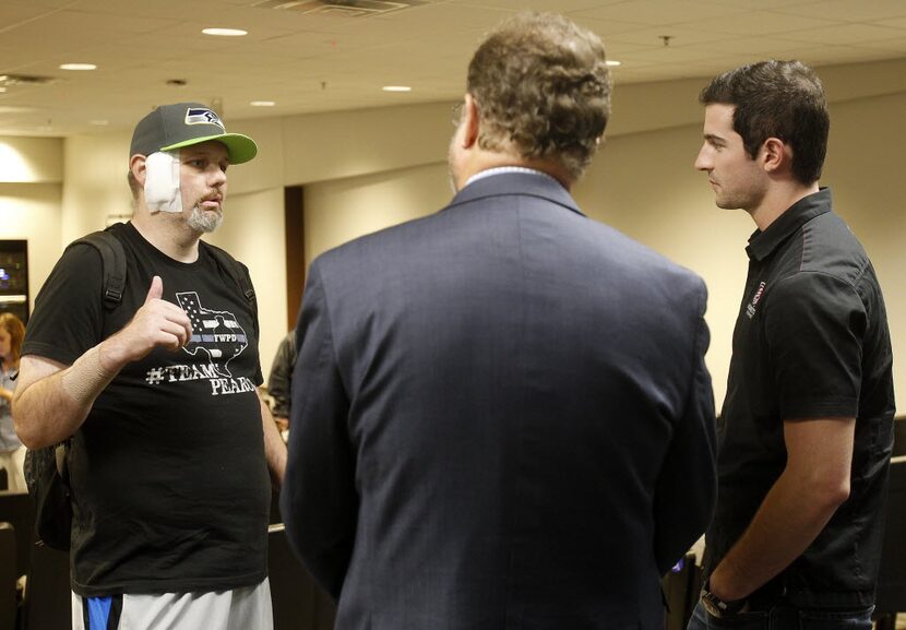 Injured police officer Matt Pearce, left, chats with Indianapolis 500 champion Alexander...