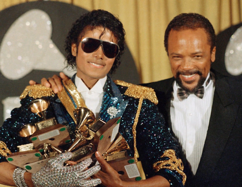 Michael Jackson, left, holds eight awards as he poses with Quincy Jones at the Grammy Awards...