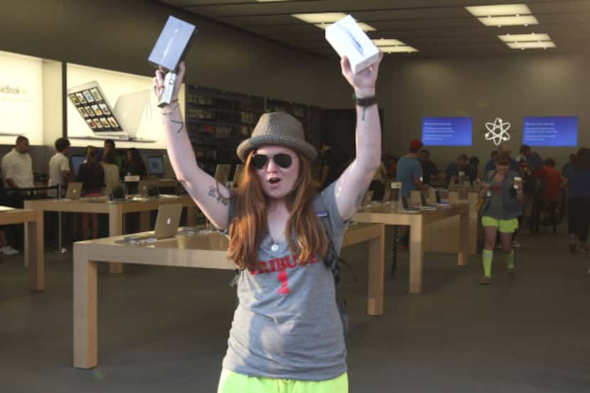 Jill Cain, who waited in line 49 hours, ecstatically leaves the Apple Store on Knox Street...
