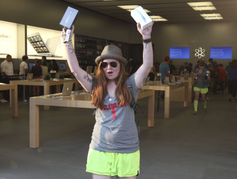 Jill Cain, who waited in line 49 hours, ecstatically leaves the Apple Store on Knox Street...