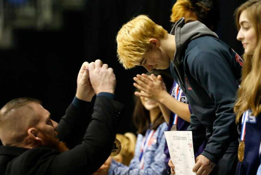 Euless Trinity's Mack Beggs receives his first place medal from Trinity head coach Travis...