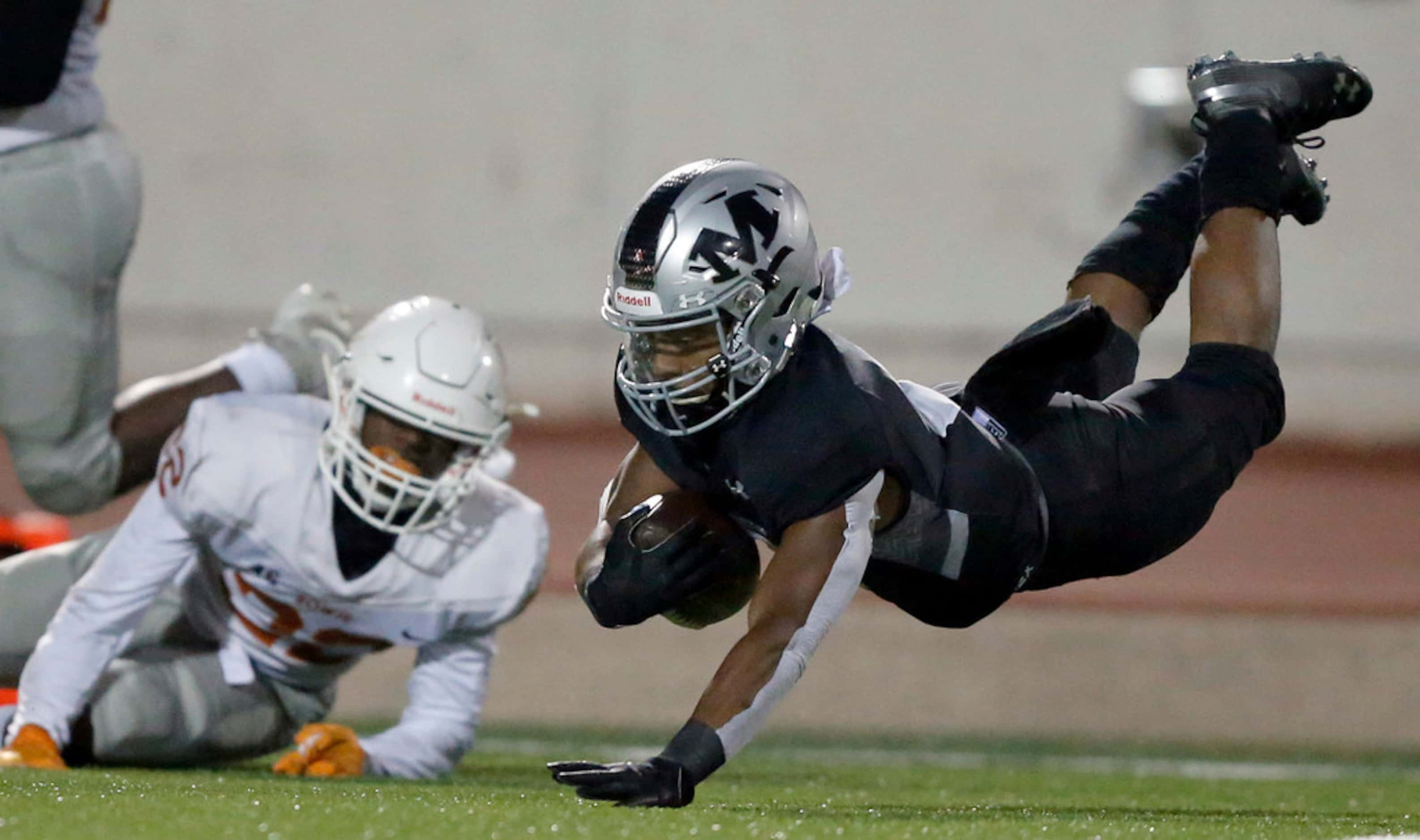 Martin running back Dwayne Williams (3) dives for extra yardage after being tripped up by...