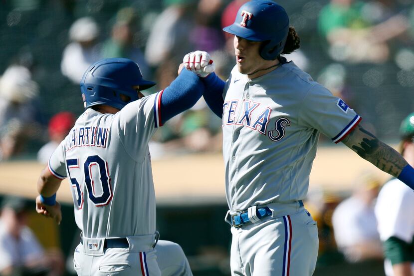 Texas Rangers' Jason Martin (50) congratulates Jonah Heim (28) after he hit a two-run home...