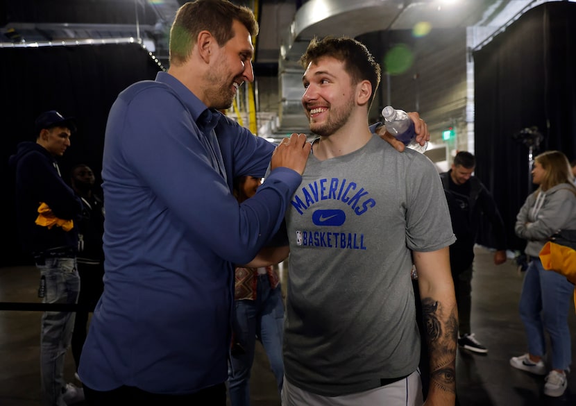 Former Dallas Mavericks forward Dirk Nowitzki congratulates guard Luka Doncic on a good...