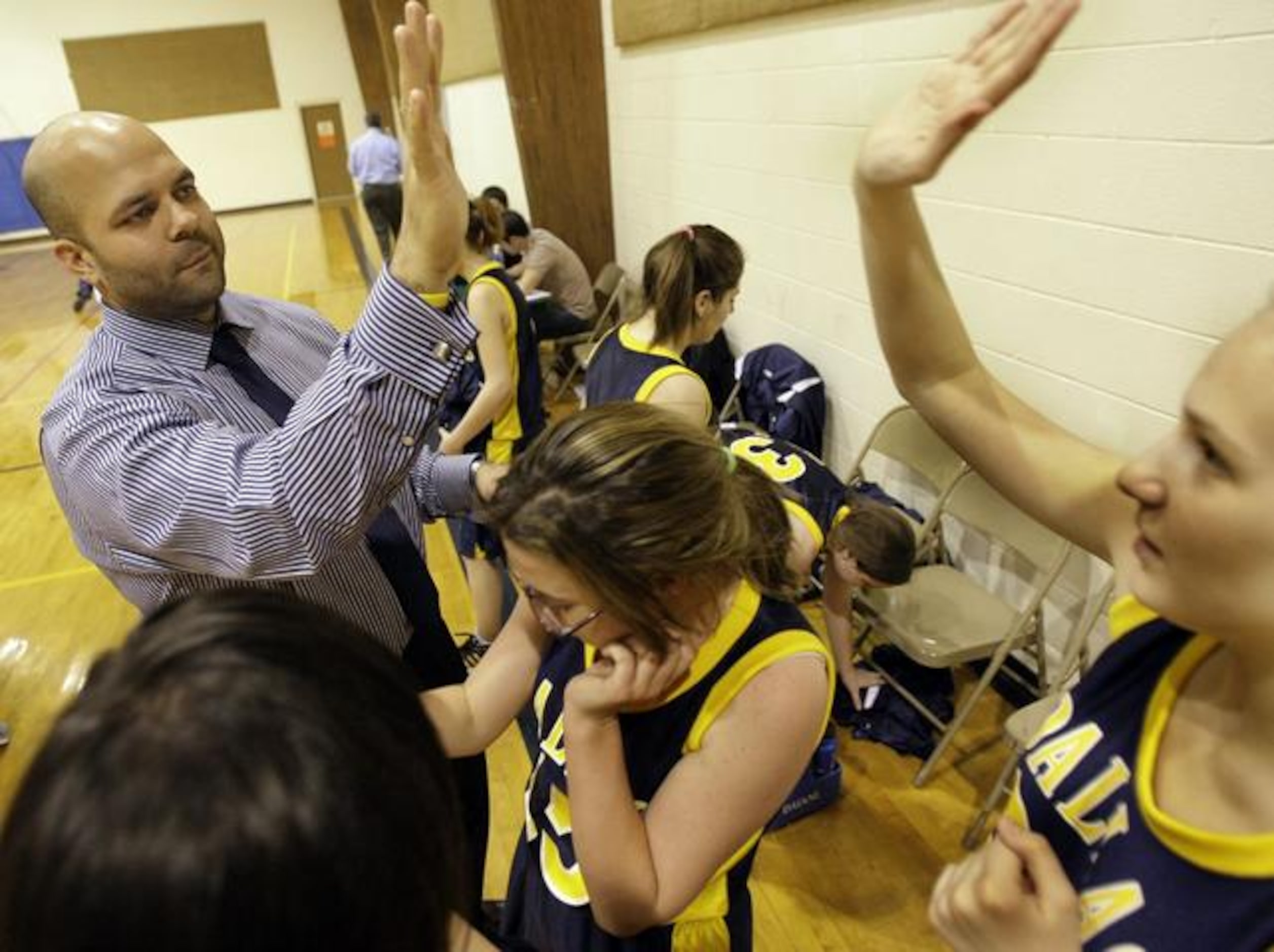 Dallas Academy coach Andrew Lott congratulates his team for its effort after a 32-10 loss to...