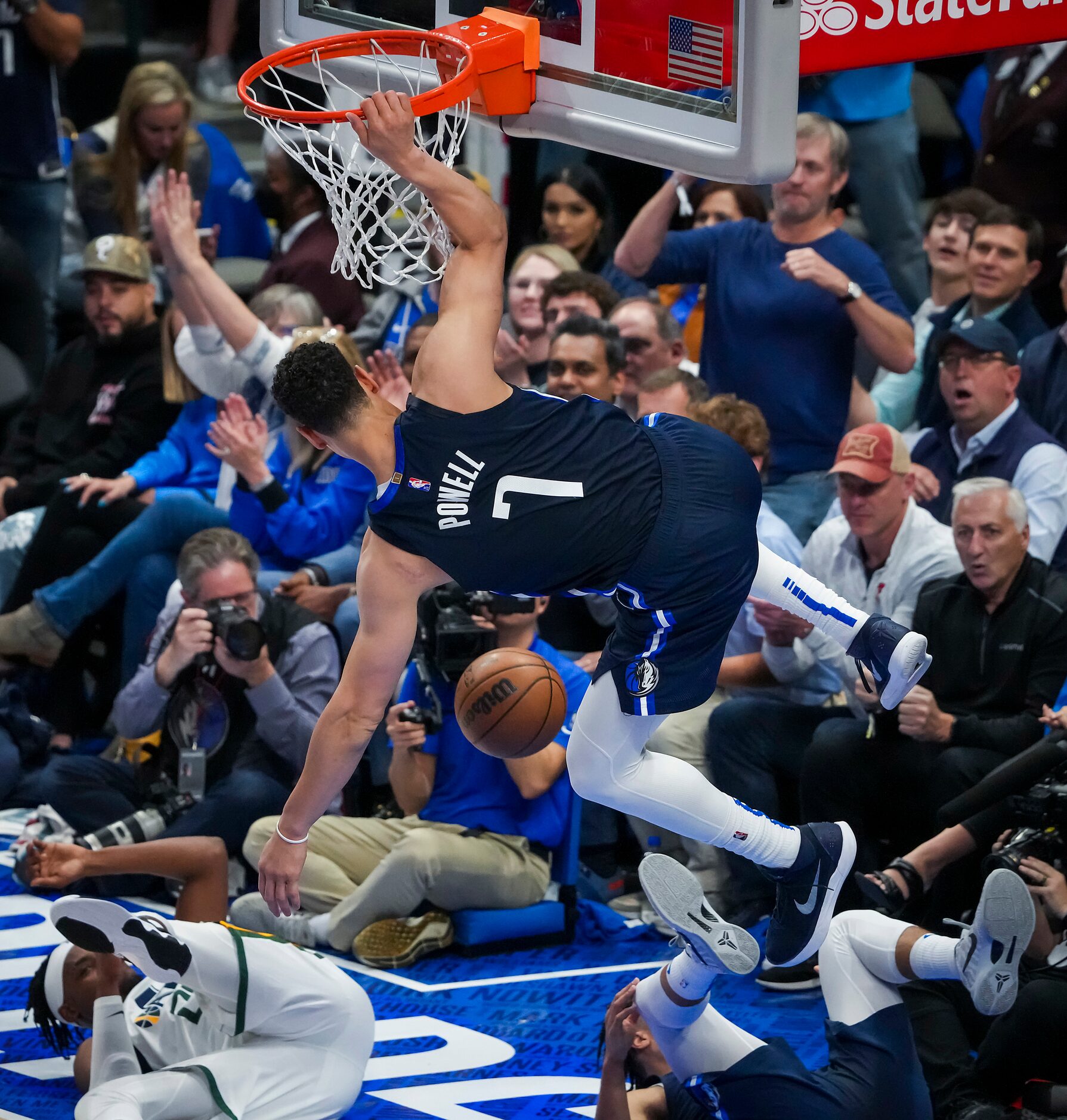 Dallas Mavericks center Dwight Powell (7) hangs on the rim on a dunk as guard Jalen Brunson...