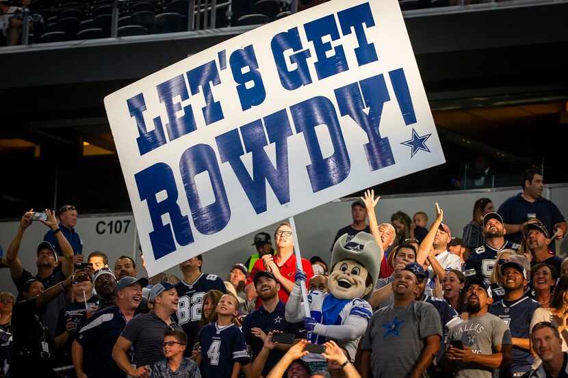 Dallas Cowboys fans cheer with mascot Rowdy before a preseason football game against the...
