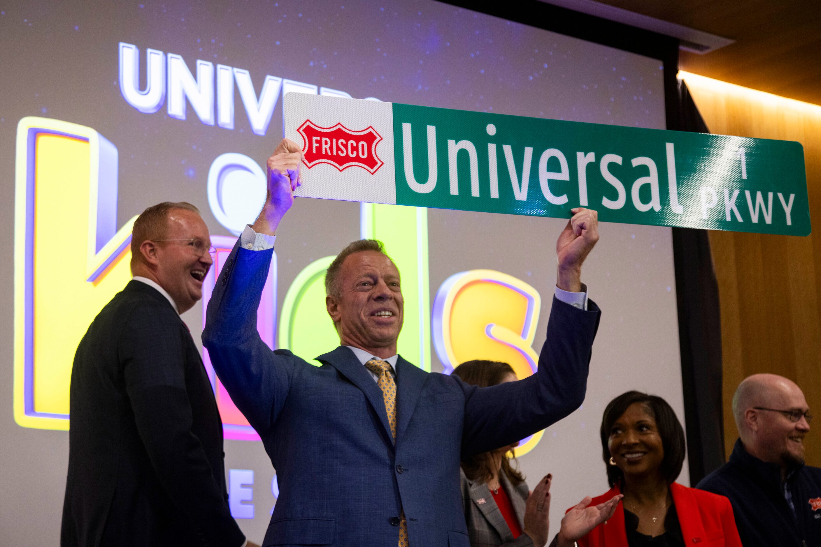 John Keating, Mayor Pro Tem, holds a Universal Parkway street sign following the...