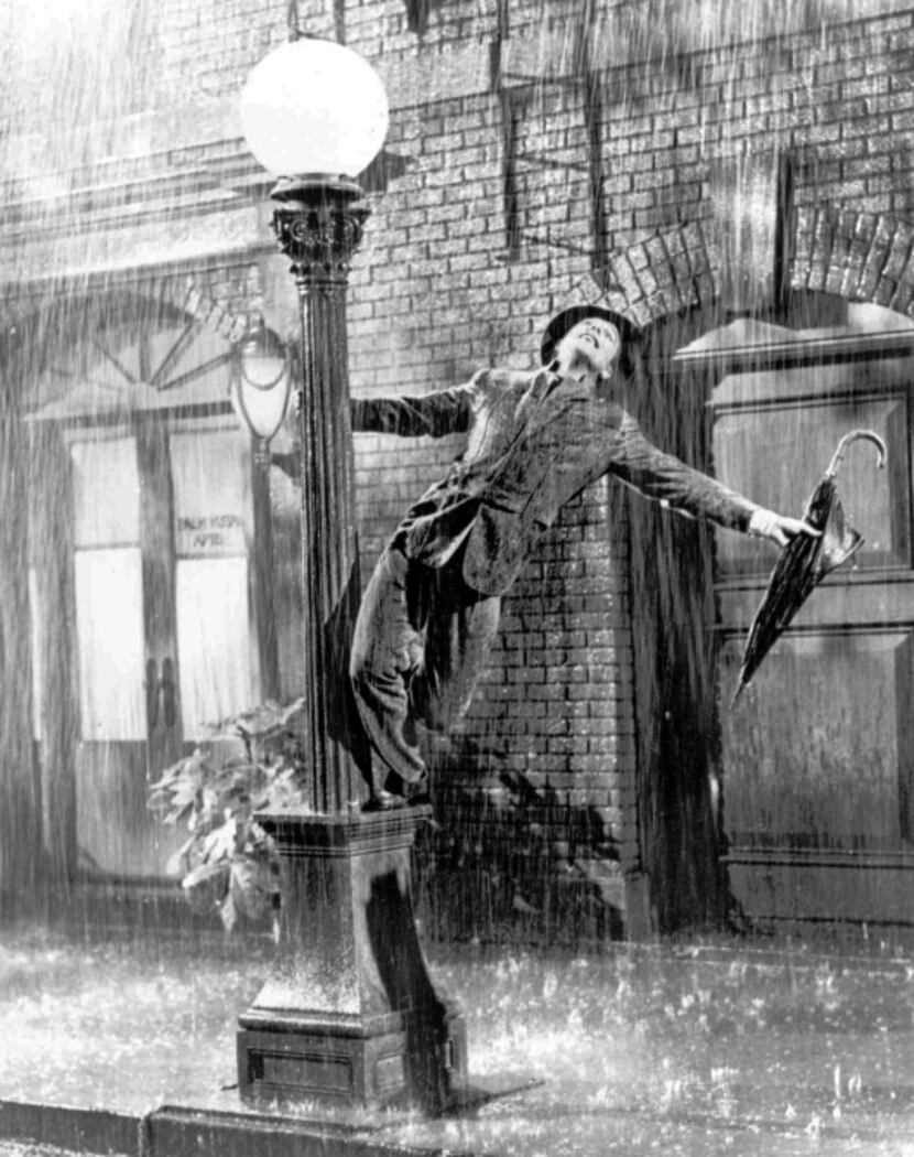 A drenched Gene Kelly twirls around a lamppost as he performs a song-and-dance number in the...
