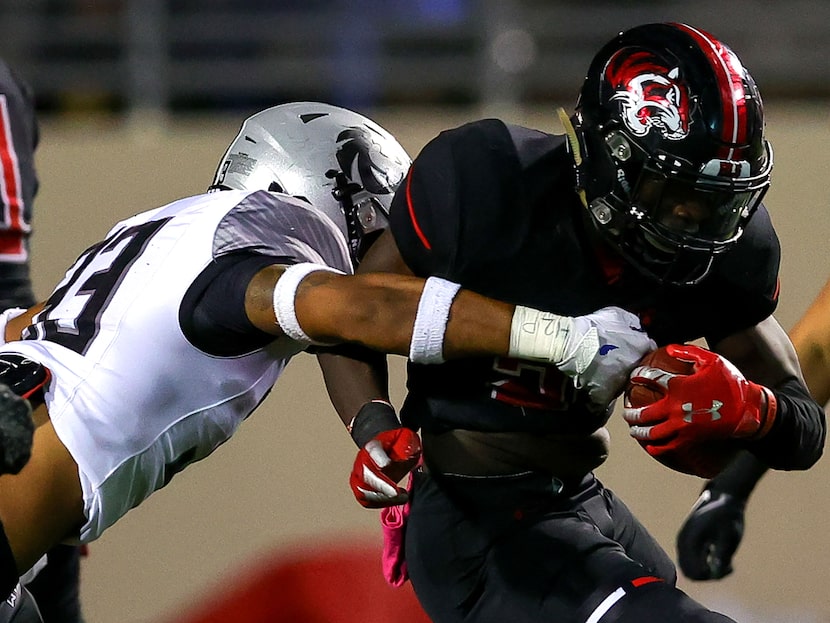 Denton Braswell running back Jaylon Burton (R) gets stopped for a short gain by Denton Guyer...