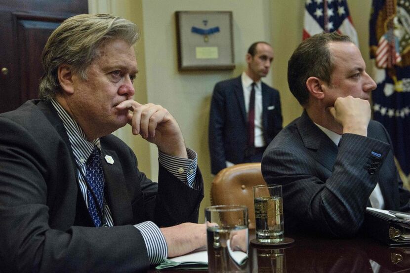 Trump advisor Steve Bannon, left, and White House Chief of Staff Reince Priebus listen to...