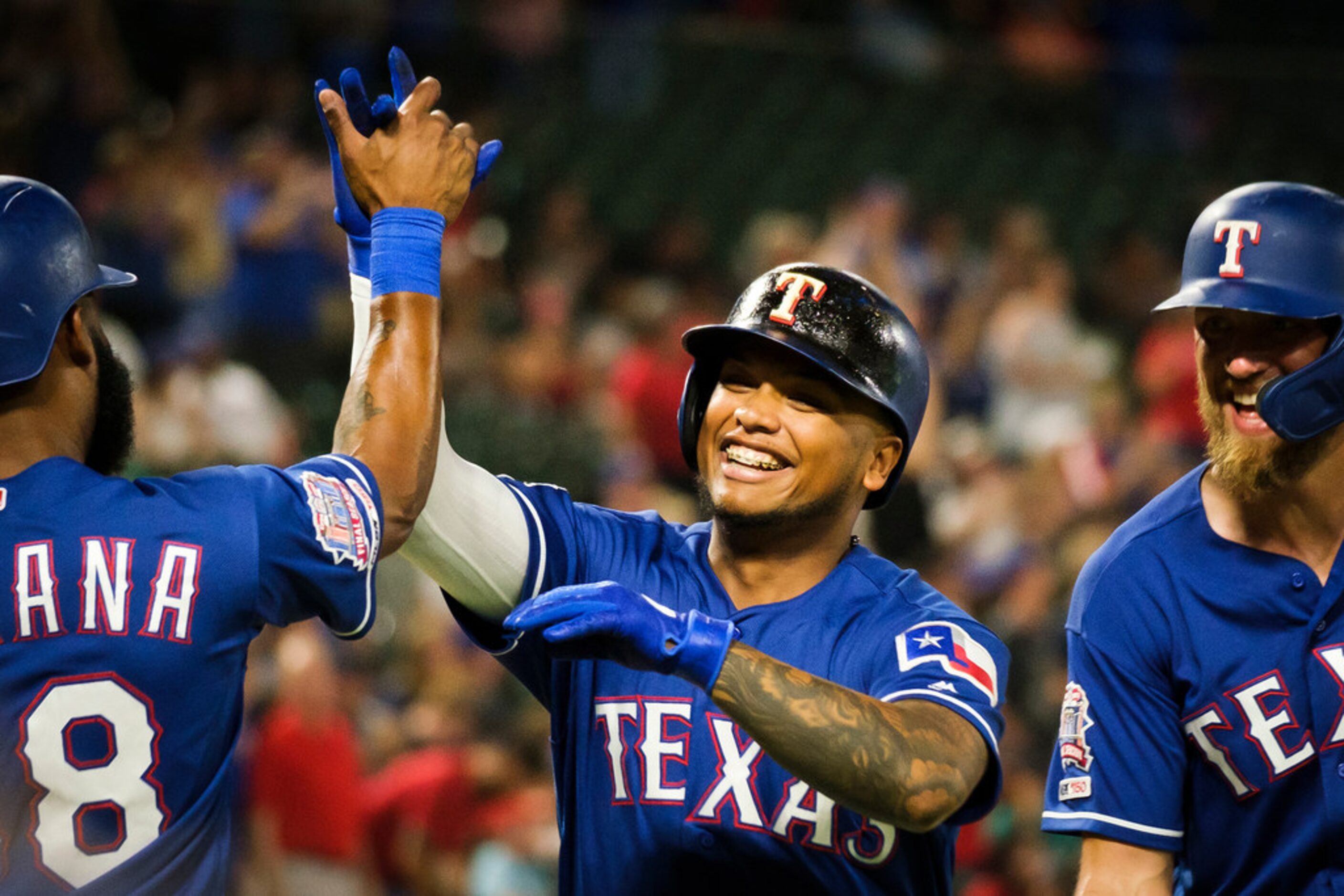 Texas Rangers left fielder Willie Calhoun celebrates with Danny Santana and Hunter Pence...