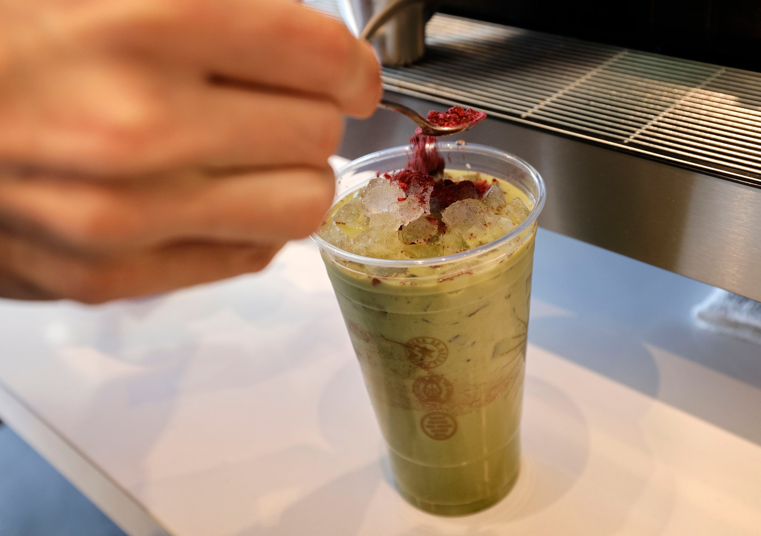 Artem Veksha, cafe manager, makes a Berry Cobbler Matcha during a soft opening of a new...