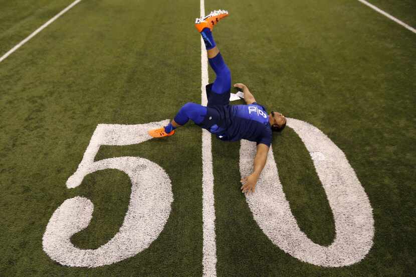 LSU offensive lineman La'El Collins stretches at the NFL football scouting combine in...