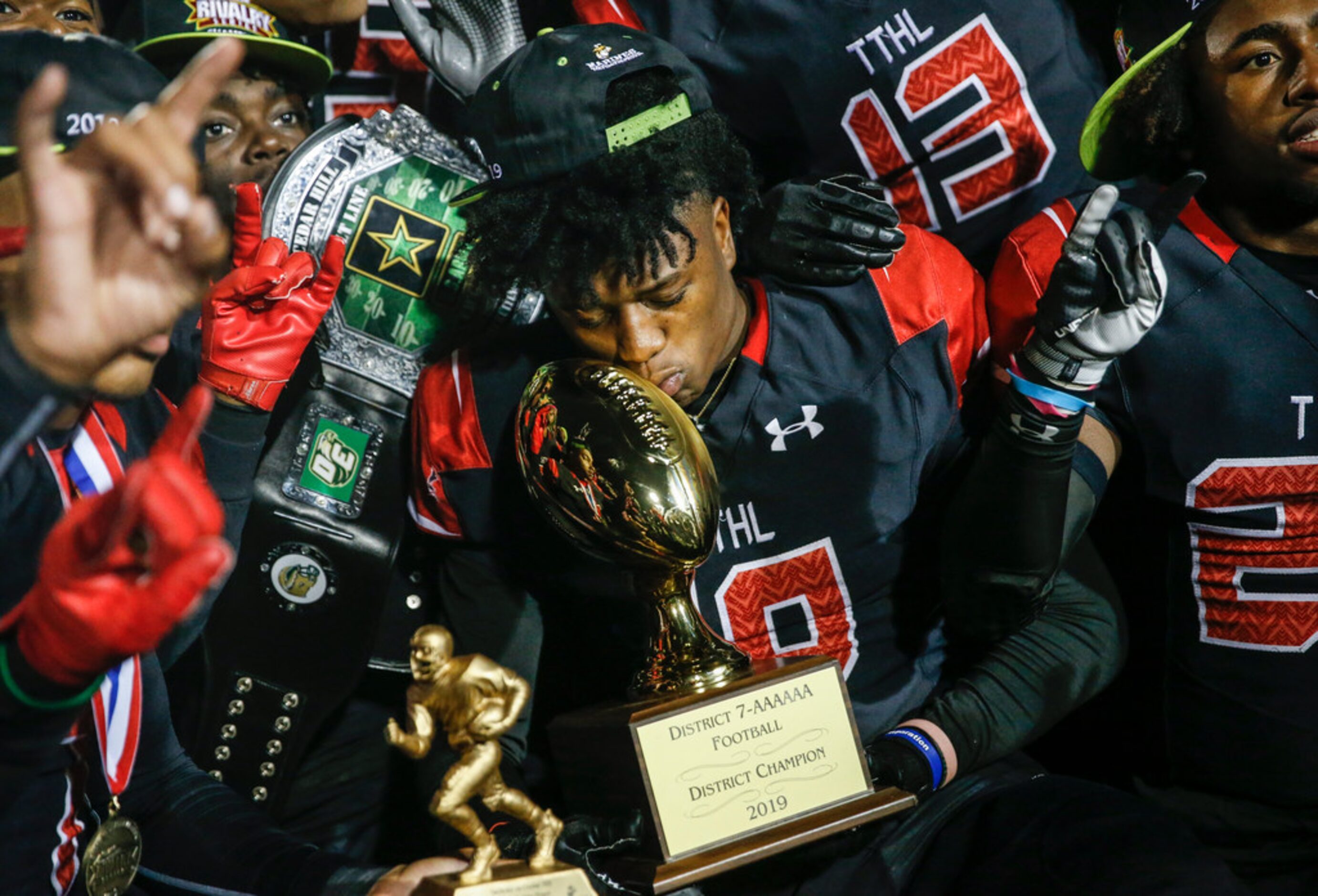 The Cedar Hill Longhorns celebrate their 7-6A district championship win over the DeSoto...