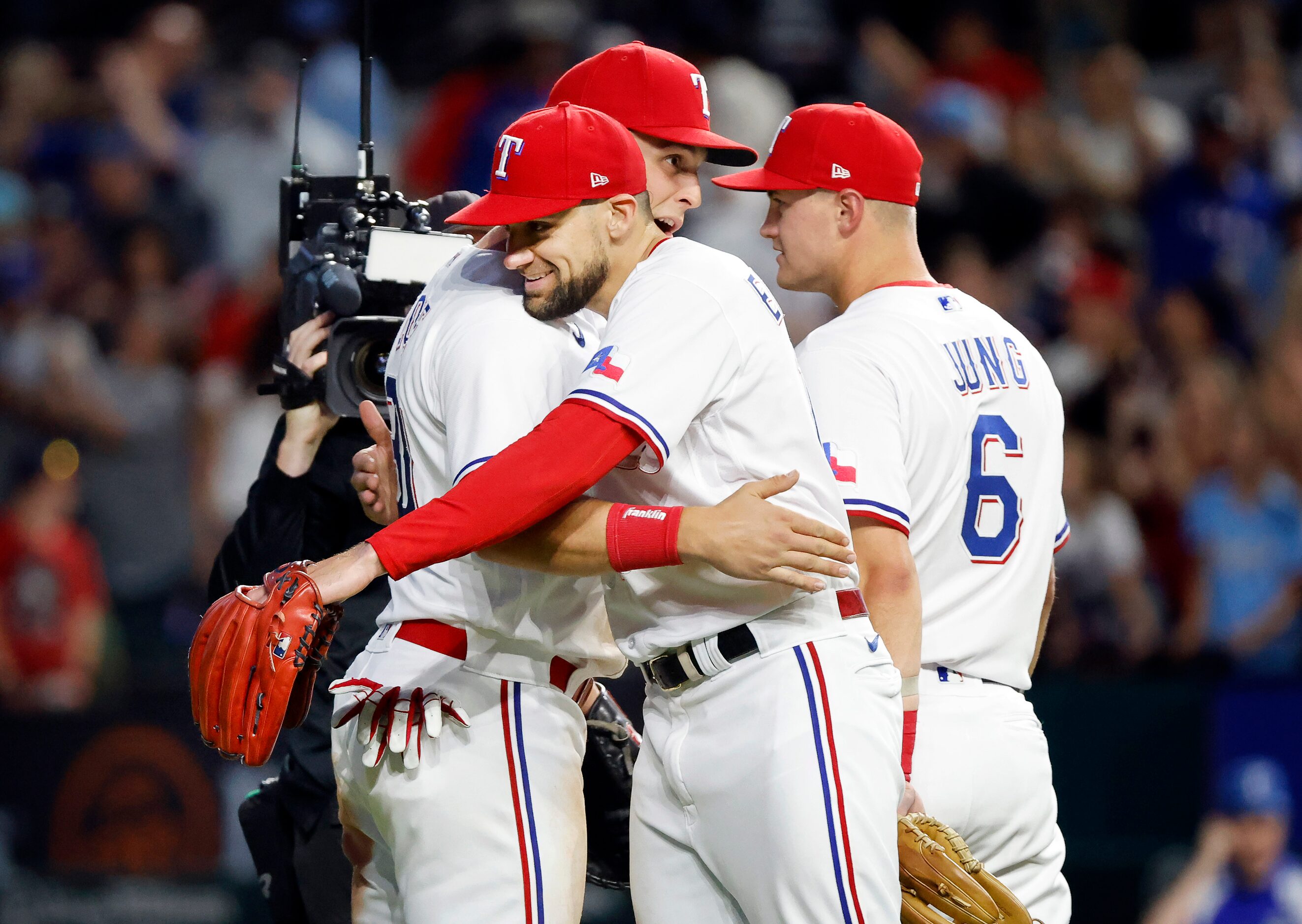 Texas Rangers starting pitcher Nathan Eovaldi (right) receives a hug from teammates...