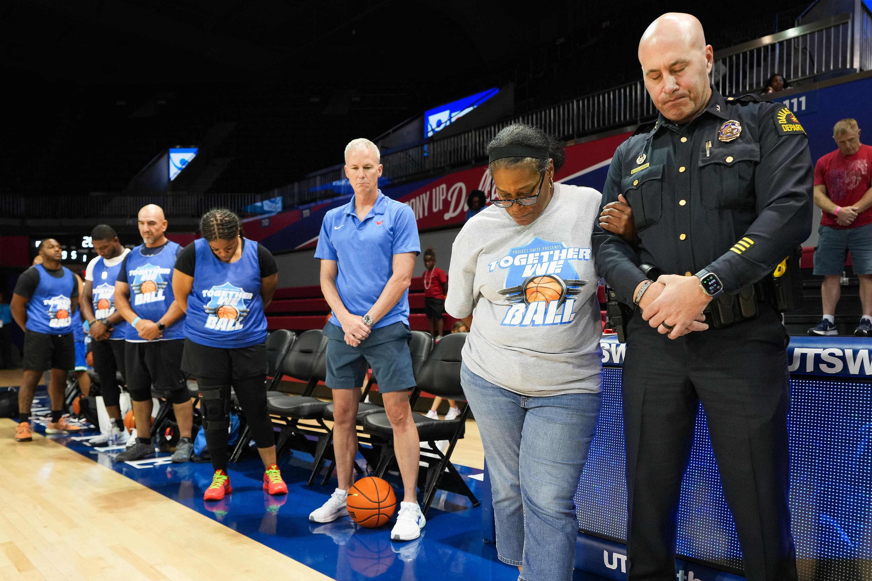 Dallas Police Department Assistant Chief Mark Villarreal (right) stands in prayer during a...