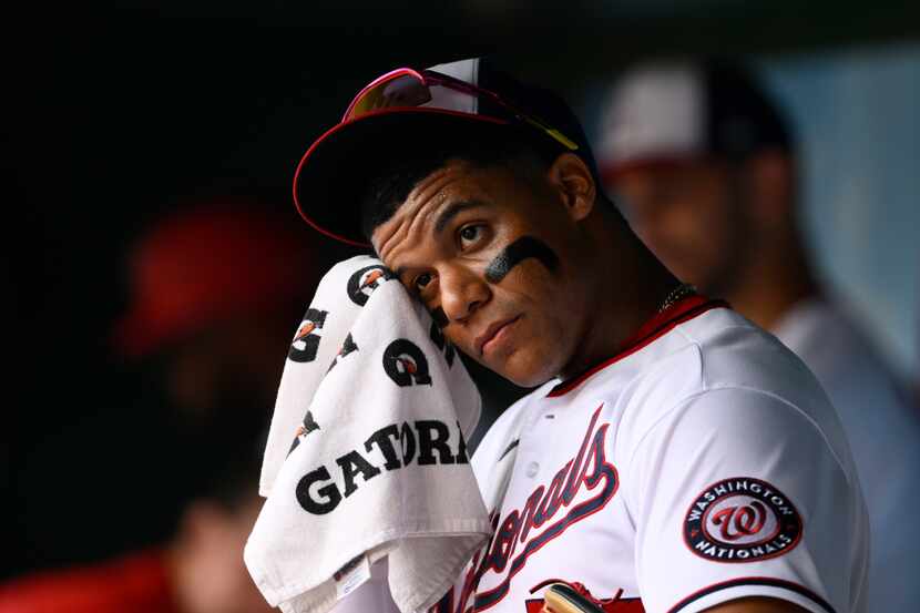 Washington Nationals' Juan Soto wipes his face in the dugout before a baseball game against...