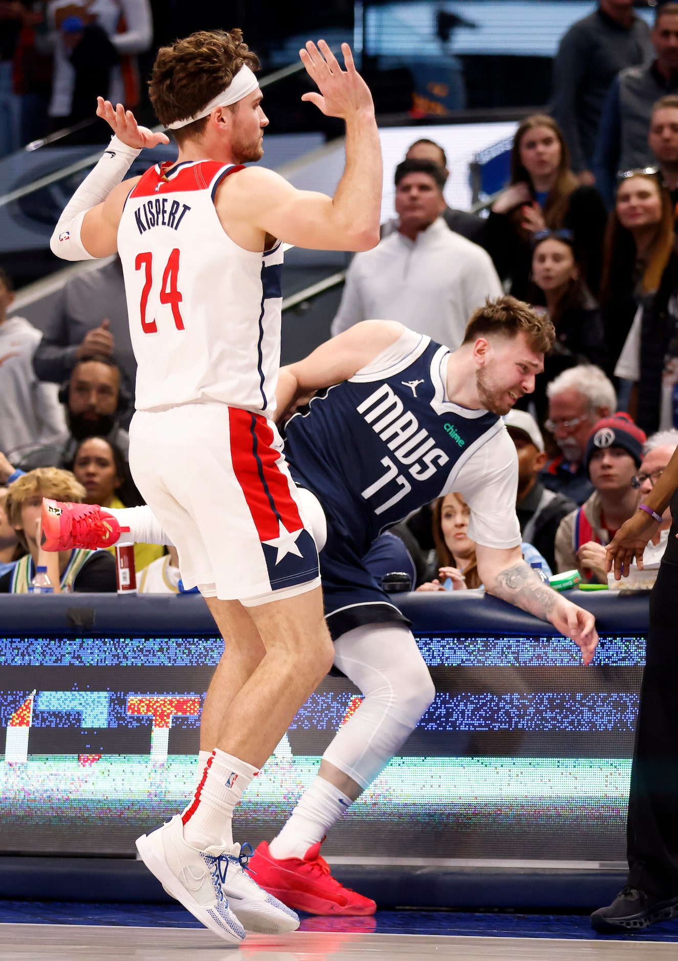 Dallas Mavericks guard Luka Doncic (77) goes flying into the scorers table as he collides...