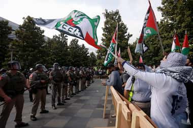 Protestors chant as law enforcement dismantle an encampment by pro-Palestinian students at...