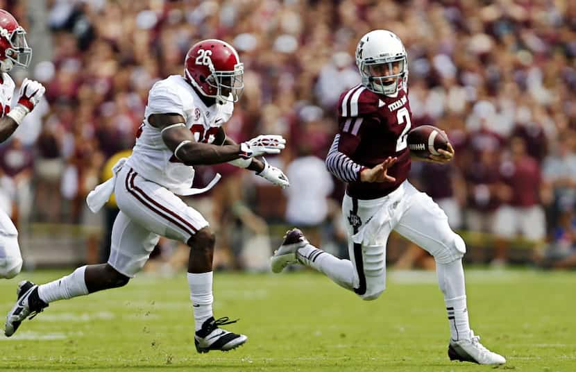 Texas A&M Aggies quarterback Johnny Manziel (2) stays ahead of Alabama Crimson Tide...