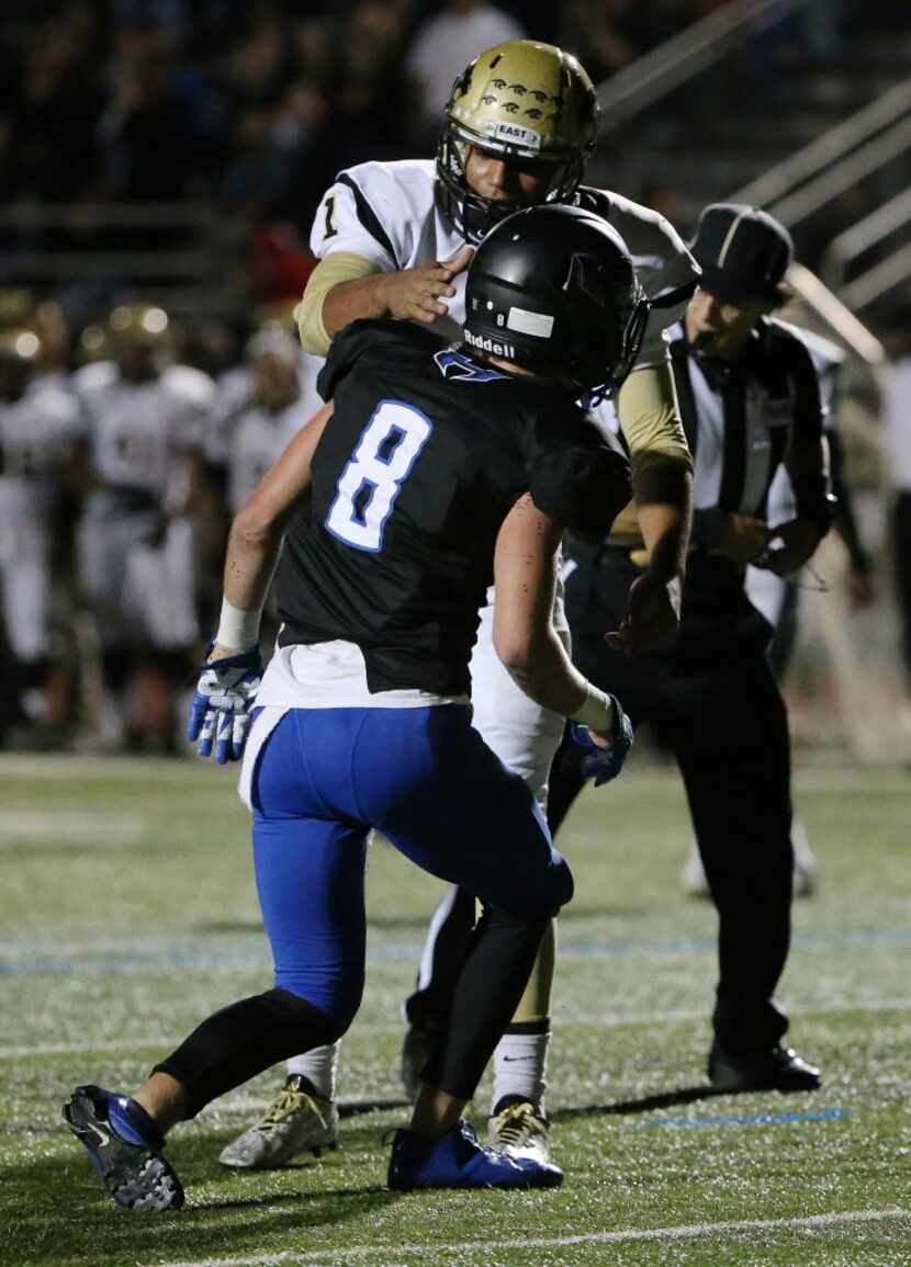 Plano East quarterback Miklo Smalls (1) pats Hebron defensive back Colton Chapin (8) on the...