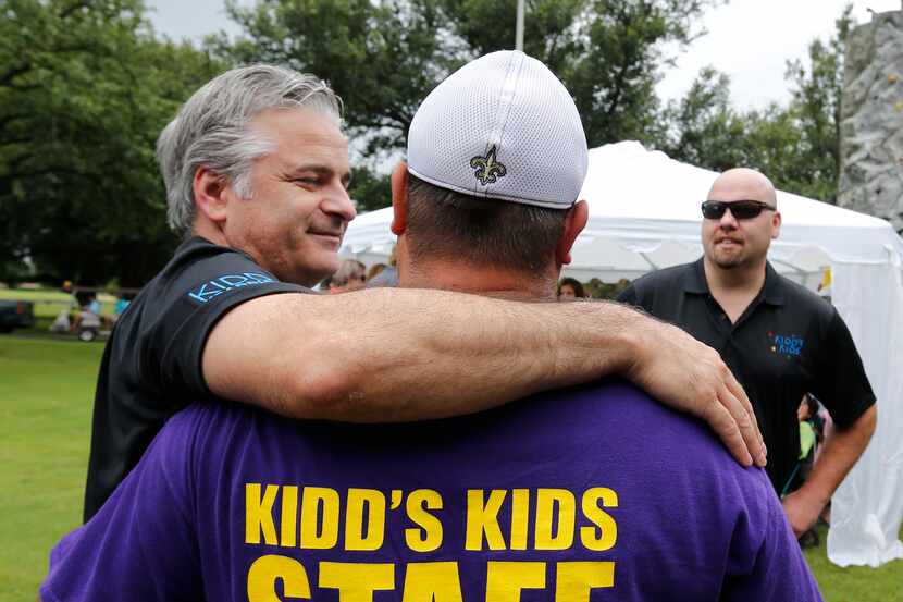 George Laughlin (left), CEO of YEA Networks, hugs a staff member at a fundraiser held at a...