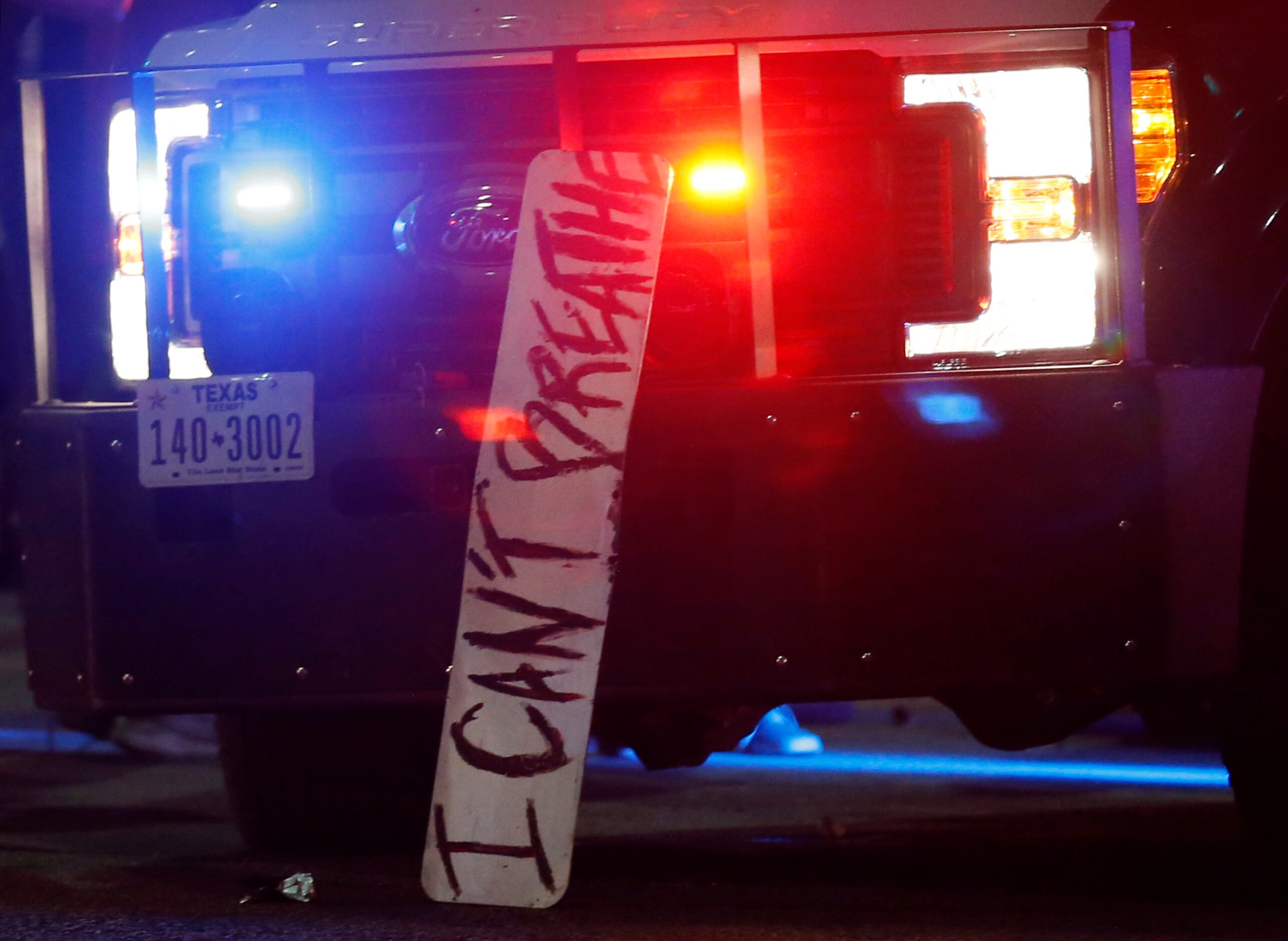 A sign stating "I Can't Breathe," rests on the front of a Dallas police vehicle as...