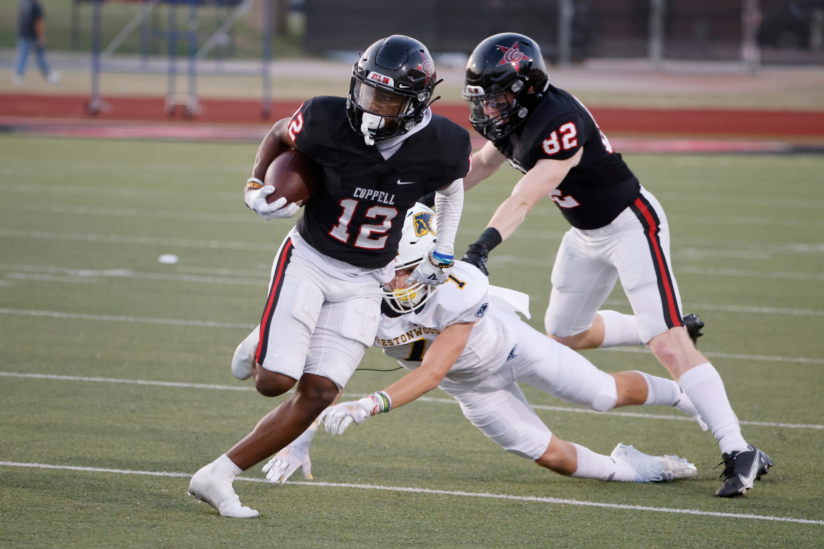 Coppell receiver Dylan Nelson (12) avoids a tackle by Prestonwood Christian Academy defender...