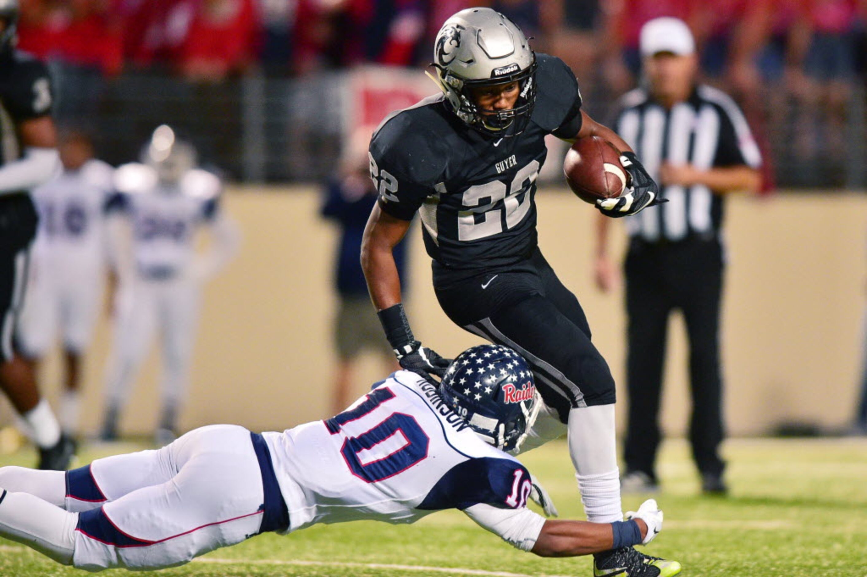 Guyer freshman running back Noah Cain (22) tries to evade a tackle by Ryan junior defensive...