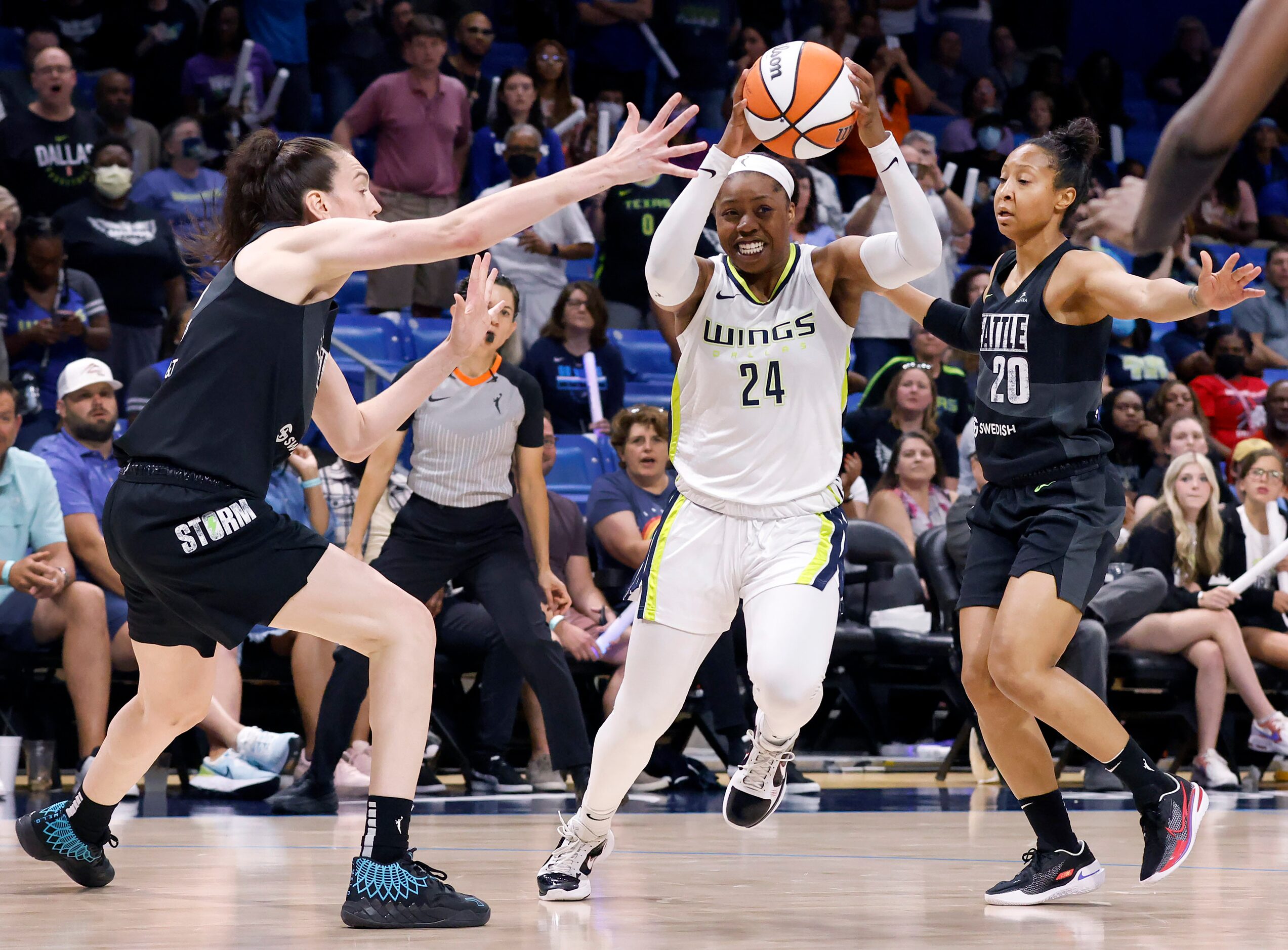 Dallas Wings guard Arike Ogunbowale (24) splits Seattle Storm forward Breanna Stewart (left)...