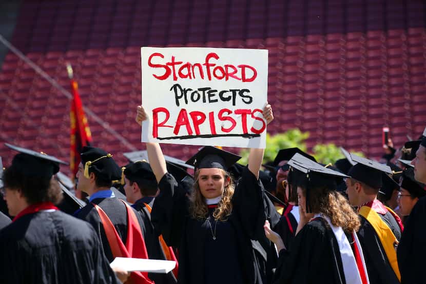FILE -- A protester holds a sign during graduation exercises at Stanford University in...