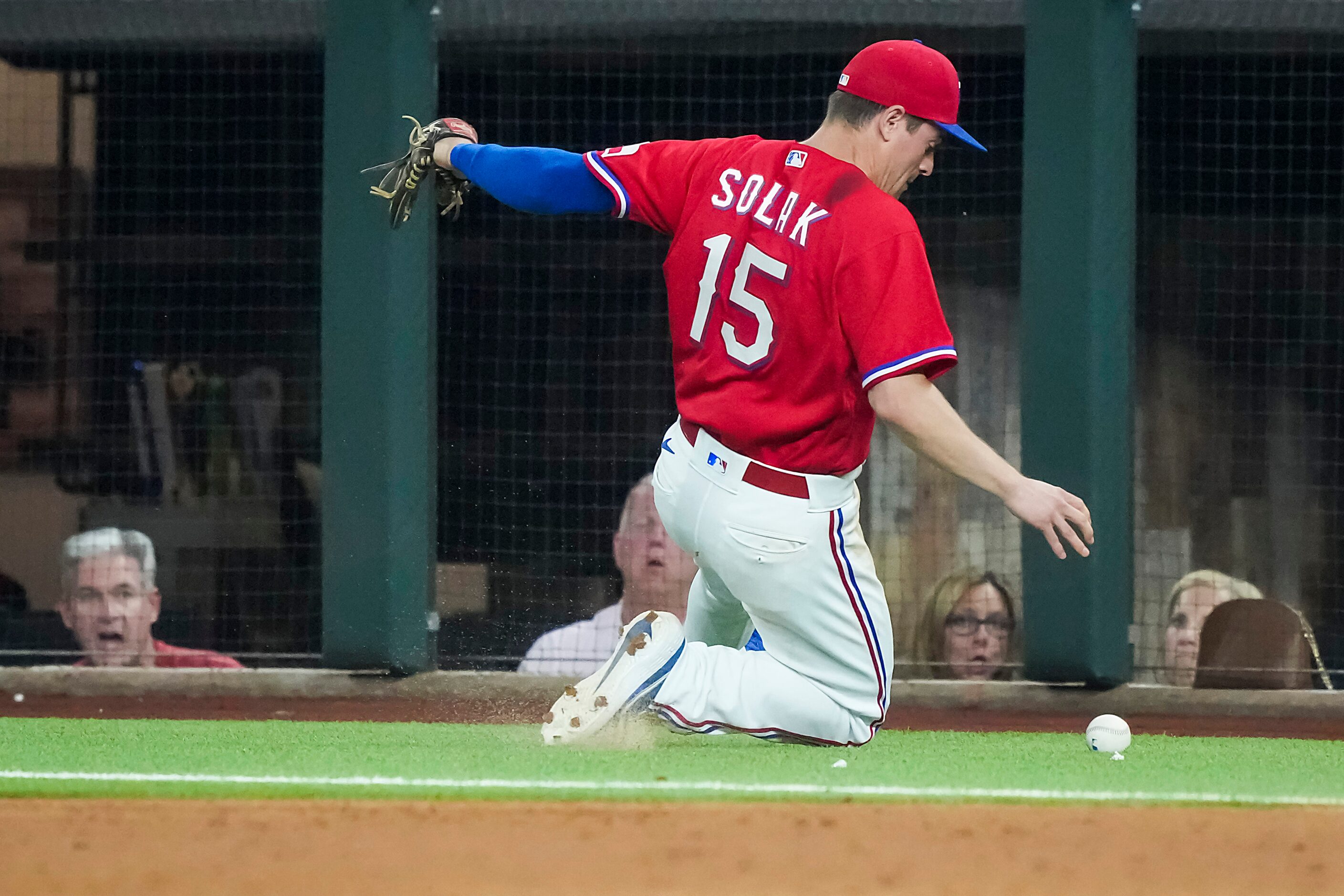 Texas Rangers second baseman Nick Solak chases an overthrown ball in foul territory during...