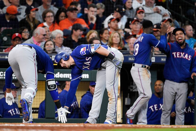 Texas Rangers' Ronald Guzman, left, celebrates his game-tying home run off Houston Astros...