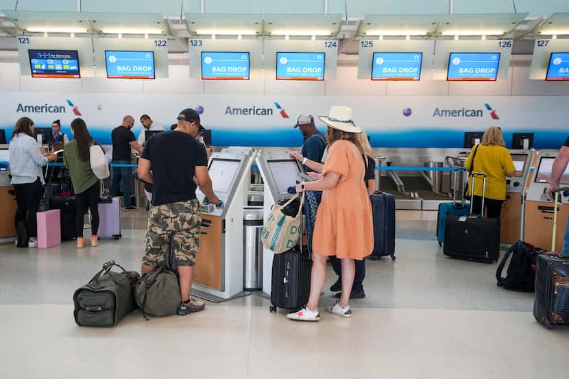 Passengers check in at the American Airlines counters  at Terminal D at DFW Airport on...