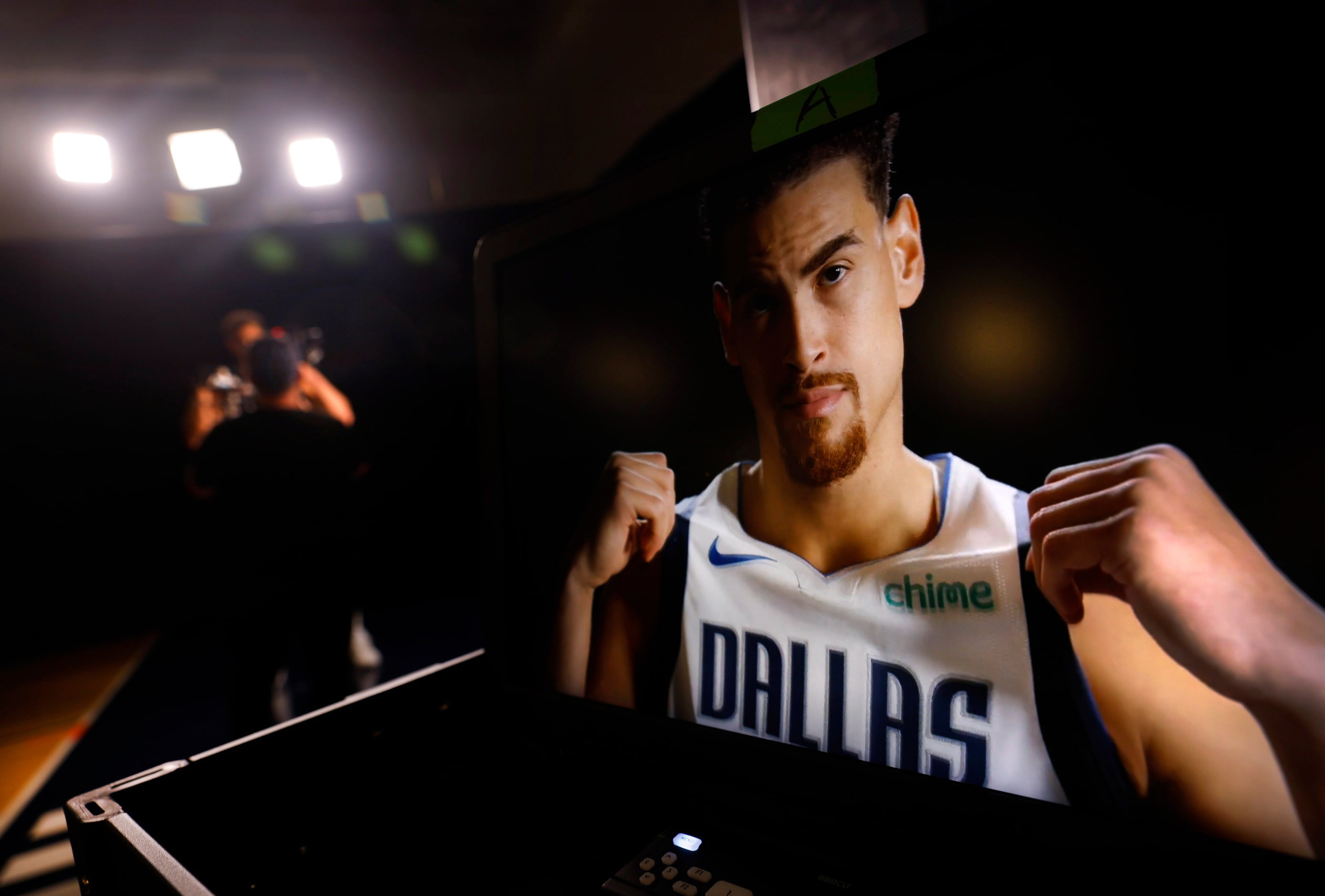 Dallas Mavericks center Dwight Powell appears on a video monitor as he is filmed for a team...