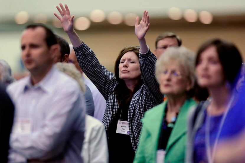 Michelle Ray, of West Plains, Mo., raises her hands in praise during the Southern Baptist...