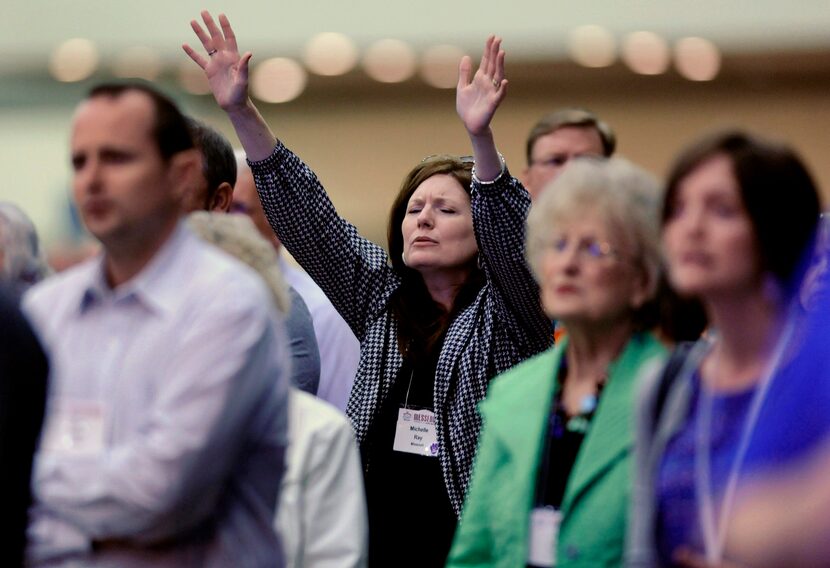 Michelle Ray, of West Plains, Mo., raises her hands in praise during the Southern Baptist...