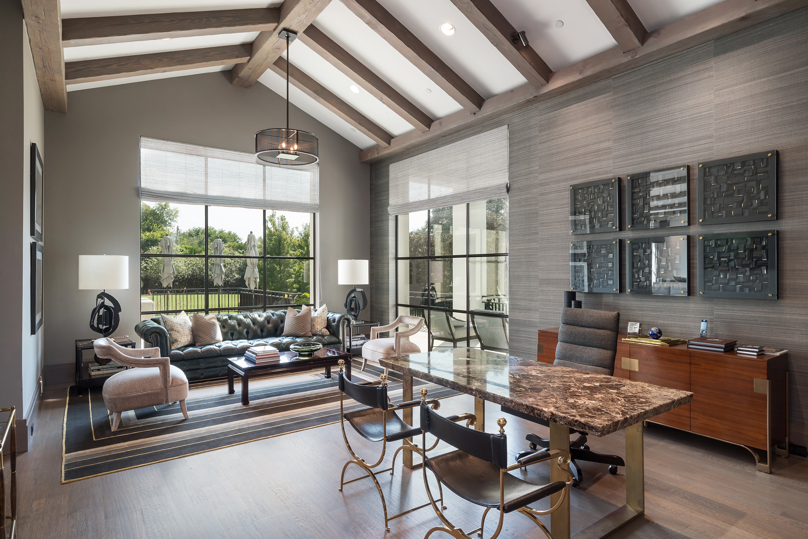 A study in the home has a vaulted ceiling and windows that overlook the property.