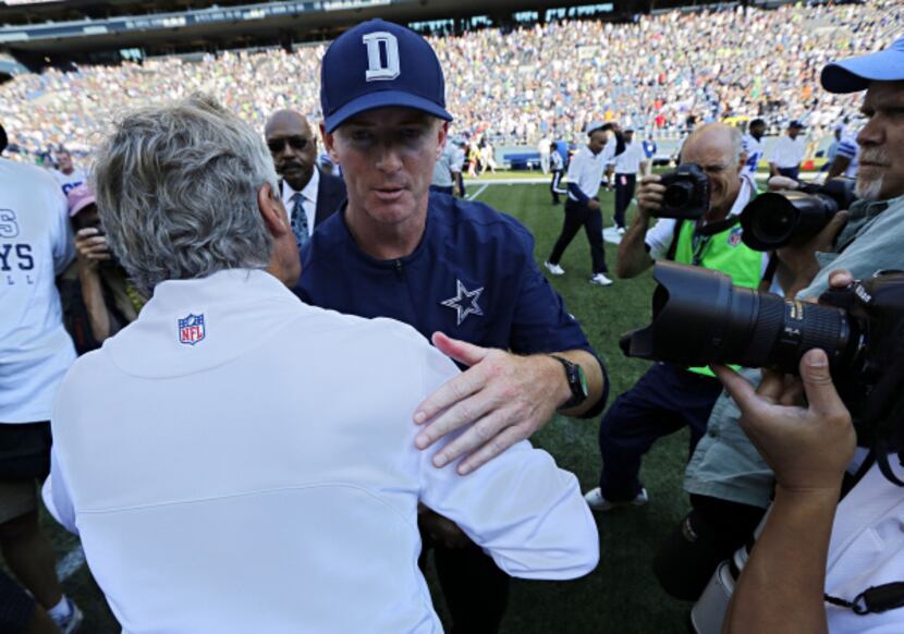 Dallas Cowboys head coach Jason Garrett (second from left) hugs Seattle Seahawks head coach...