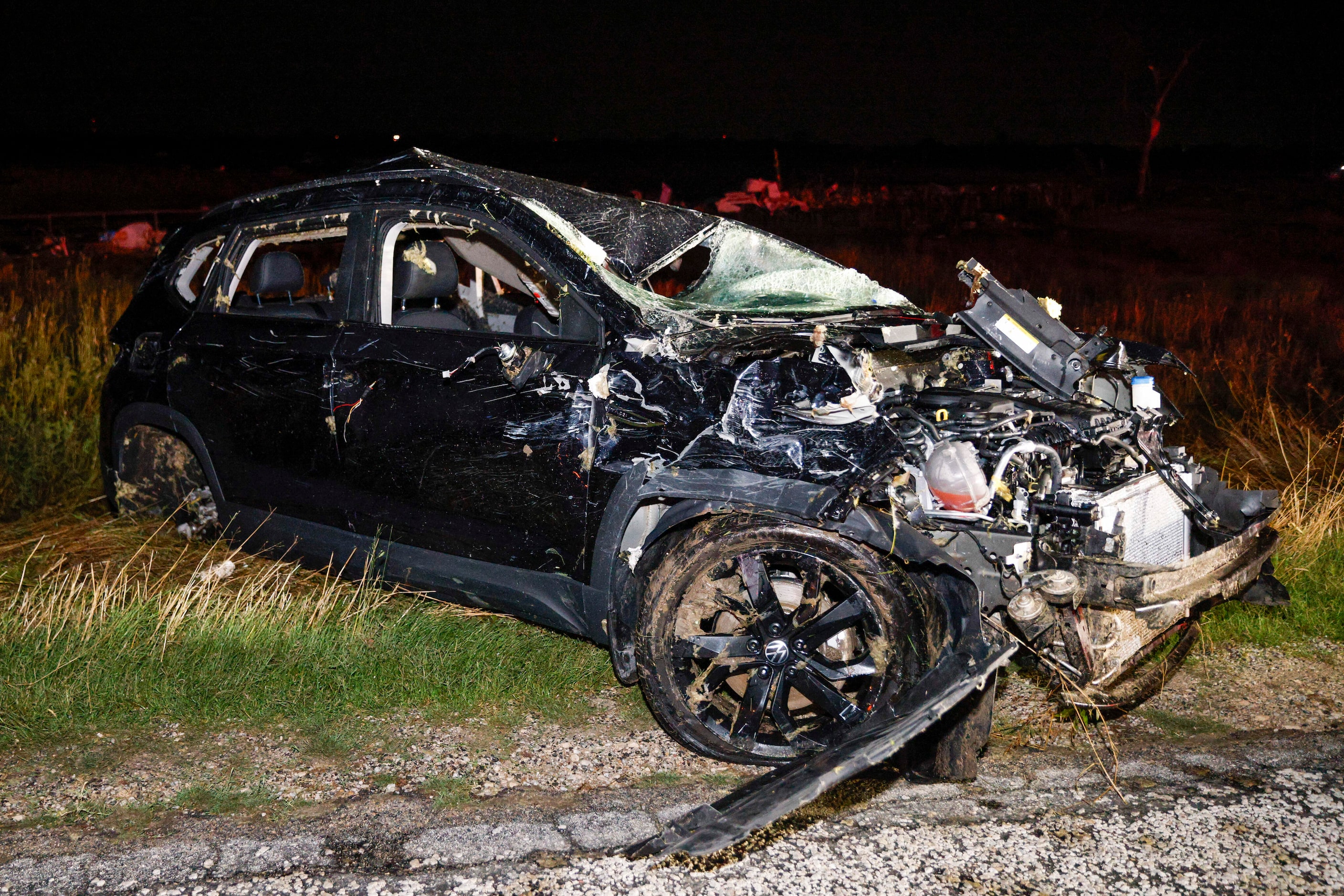 A heavily damaged Volkswagen SUV is seen alongside East Lone Oak Road near a Shell gas...