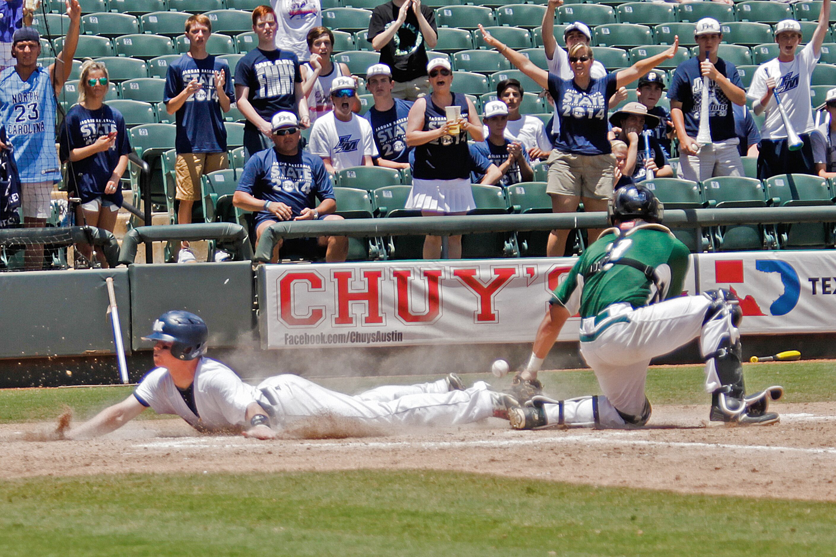 Flower Mound player Mitch Andrews (5) slides into home base while San Antonio Reagan player...