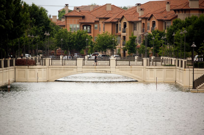 A resident crosses a canal bridge near Lago de Claire, where a woman's body was pulled from...