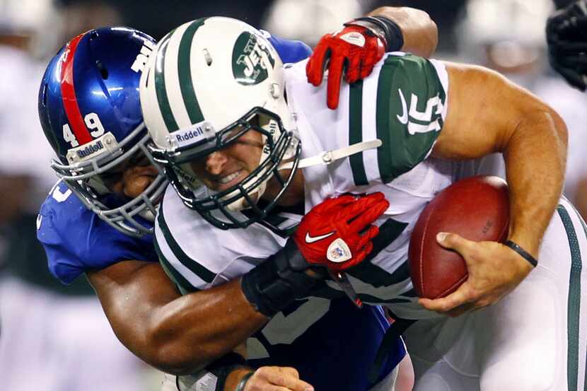 New York Giants linebacker Spencer Paysinger (49) tackles New York Jets quarterback Tim...