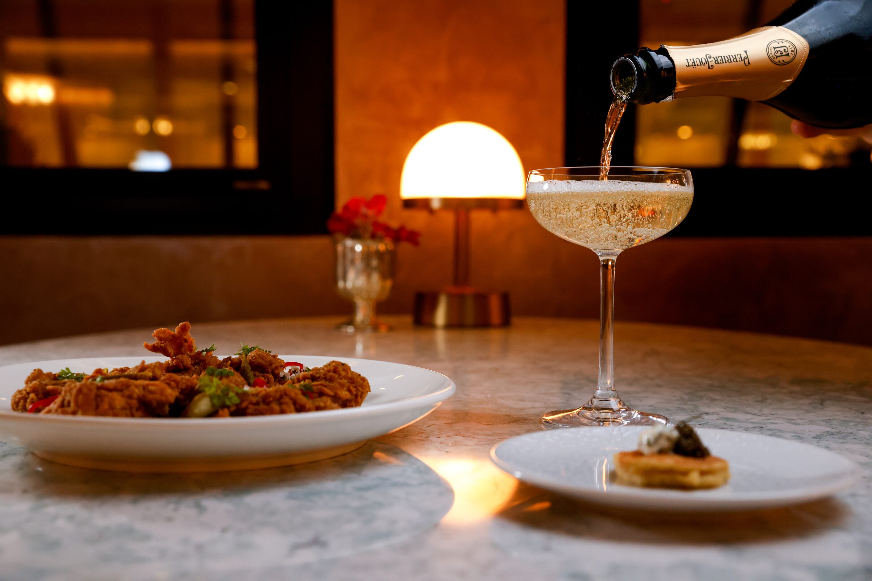 The fried chicken Provençal (left) and Buckwheat Potato Blini topped with Osetra Caviar and...