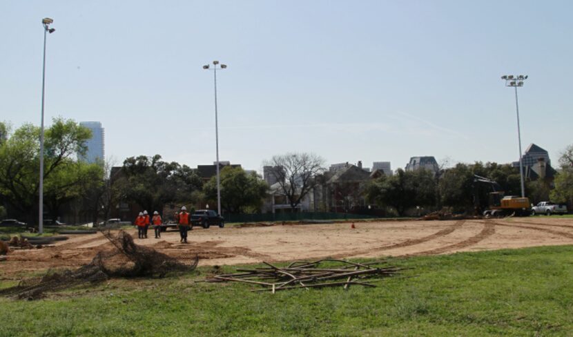 Construction workers remove a fence in Griggs Park in Uptown in preparation for a redo of...